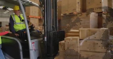 Lojistik personeli pano dağıtıyor, forklift sürücüsü okuma özelliklerini palet koridoruna kaydırıyor. Endüstriyel, takım çalışması, verimlilik, üretim, güvenlik, operasyonel, organizasyonel