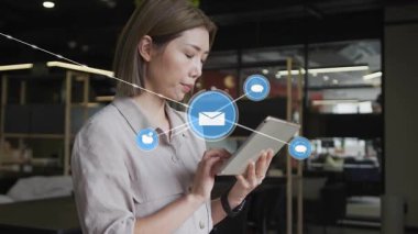 İş kadını tableti tıklatıyor ve dijital iletişim için zarf ve ağ simgeleri oluşturuyor. Teknoloji, bağlantı, dijital, ağ, iletişim, profesyonel, modern