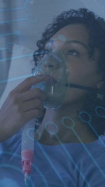 Oksijen maskesi kullanan Afrikalı Amerikalı bir kadının veri işleme animasyonu. Küresel covid 19 salgın, ilaç ve sağlık hizmetleri konsepti dijital olarak oluşturulmuş video.