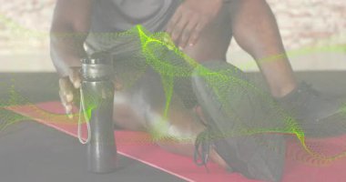 Fitness meraklısı kırmızı paspasın üzerinde vites değiştiriyor ve su şişesini alıyor sonra da su içmek için kapağı açıyor. Sporcu, hidrasyon, güç, sağlık, spor salonu, aktif giysi, kararlılık