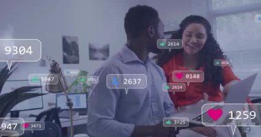 Meslektaşlar, takip eden simgelerle dizüstü bilgisayarı izliyor ve pazarlama için kalp atışı gibi yakıt dolduruyorlar. İşbirliği, takım çalışması, dijital pazarlama, profesyonel, modern, canlı, başarı