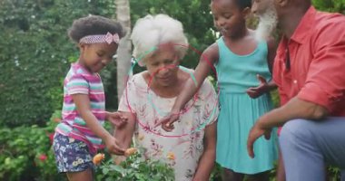 Animated rings spinning over blurred garden educating grandchildren in gardening with watering can. Family, gardening, multigenerational, outdoor, nature, relaxation, activity