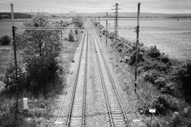 19 'da Çek Cumhuriyeti' nin Vyskov kenti yakınlarındaki demiryolu hattı. Mayıs 2025 tarihli siyah beyaz film - taranmış 35 mm filmin bulanıklığı ve gürültüsü görüntüde kasıtlı olarak bırakıldı