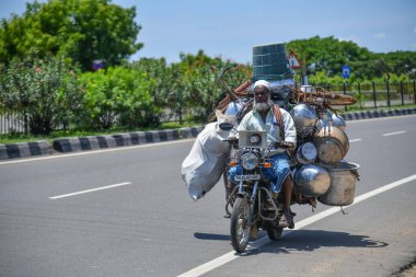 Viluppuram, Hindistan: 28 Ağustos 2022: Yaşlı adam Hindistan Ulusal Otoyol Seyahati 'nde aşırı yüklü bagajla bisikletini sürüyor. Hint Yolu 'nda iki tekerlekli araç yüklendi..