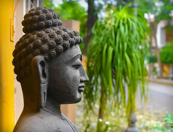 Side View of Buddha Statue Isolated On Outdoor French Colony Background, Granite Buddha Statue Portrait.