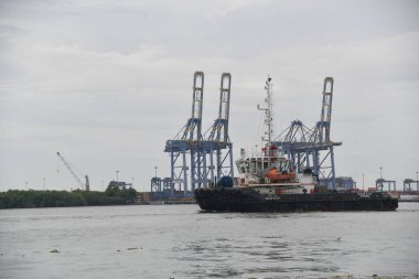 Kochi, Hindistan - 2 Eylül 2023: Cochin Limanı manzarası durgun. Lojistik ve ulaşım faaliyetleri. Hindistan 'ın Kerala kıyı eyaleti Kochi yakınlarındaki okyanusta hareket eden büyük bir konteyner gemisi..