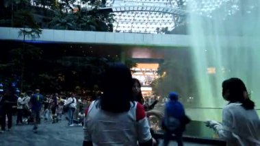 Changi Havalimanı, Singapur - 30 Temmuz 2024: Jewel Changi Havalimanı 'ndaki World Largest Indoor Water Falls' un zaman aşımı. Indore Şelalesi 'nin önünde fotoğraf çeken insanlar. Singapur Mücevheri..