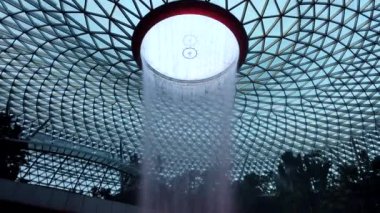 Changi Havalimanı, Singapur - 30 Temmuz 2024: Jewel Changi Havalimanı 'ndaki World Largest Indoor Water Falls' un zaman aşımı. Indore Şelalesi 'nin önünde fotoğraf çeken insanlar. Singapur Mücevheri..