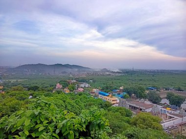 Ağaçların, binaların ve dağların en tepedeki manzarası.