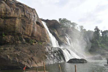 The Heavy Water in Athirapilly Waterfalls with Smoke. clipart