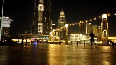 Dubai - BAE: 7 Mart 2025: Burj Halife 'nin gece vakti gerçekleşen çarpıcı zaman atlaması, yakındaki bir parktan canlı ışık gösterisi, su çeşmesi görüntüsü ve Dubais' in hayat dolu gece hayatından keyif alan insanlar.