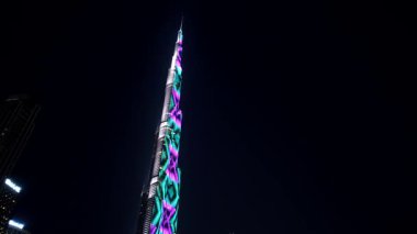 Dubai - BAE: 7 Mart 2025: Burj Halife 'nin gece vakti gerçekleşen çarpıcı zaman atlaması, yakındaki bir parktan canlı ışık gösterisi, su çeşmesi görüntüsü ve Dubais' in hayat dolu gece hayatından keyif alan insanlar.