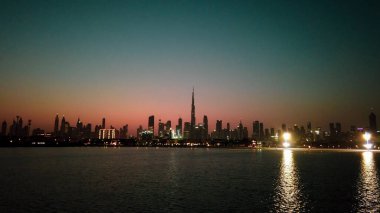 Dubai 'nin güzel gün batımı manzarası. Burj Halife silueti, Dubai Creek Limanı' ndan yakalandı..