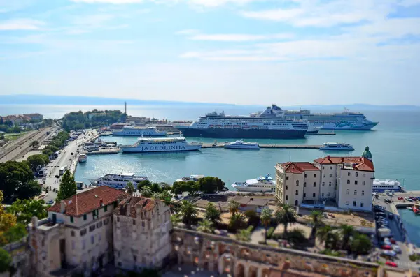 Split, Hırvatistan - 2 Ekim 2015: Jadrolinija feribotları, yolcu gemileri ve Adriyatik Denizi kıyısındaki kıyı binalarını gösteren eğimli minyatür bir efektle Split Limanı 'nın havadan görünüşü.
