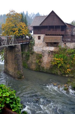 Rastoke Hırvatistan. 8 Ekim 2015. Sahne kıyısı değirmenleri ve arkaplanda köprüler olan çağlayan suların üzerindeki eski ahşap binalar.