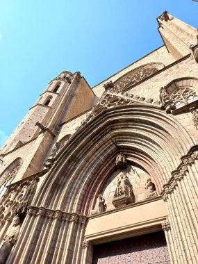 Barselona Katalonya İspanya. 10 Nisan 2025. Santa Maria del Mar Kilisesi 'nin dışı Katalan Gotik mimarisini gösteriyor. El Born bölgesinde kemerler ve oymalı giriş.