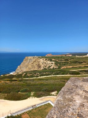 Sesimbra Portekiz 'deki Cape Espichel deniz fenerinin tepesinden geniş bir manzara dramatik sahil uçurumları, verimli arazi ve geleneksel sahil mimarisini yakalıyor.