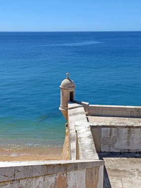 Portekiz 'de panoramik okyanus manzaralı ve parlak güneşli gökyüzü olan Susimbra Kalesi' nin kıyısındaki küçük kubbe şeklindeki koruma kulesi.
