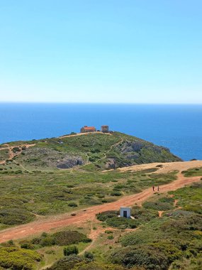 Sesimbra Portekiz 'deki Cape Espichel deniz fenerinin tepesinden geniş bir manzara dramatik sahil uçurumları, verimli arazi ve geleneksel sahil mimarisini yakalıyor.