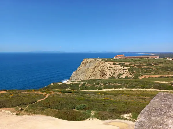 Sesimbra Portekiz 'deki Cape Espichel deniz fenerinin tepesinden geniş bir manzara dramatik sahil uçurumları, verimli arazi ve geleneksel sahil mimarisini yakalıyor.