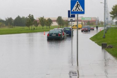 Şehrin caddesinde su basmış arabalar. Sağanak yağmurdan sonra sokak. Su motora, şanzıman parçalarına ya da başka yerlere girebilir. Afet Motorlu Taşıtlar Sigortası Teması. Şiddetli hava konsepti 09 21 2017