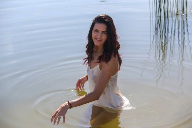 Portrait of a beautiful girl in a white wet shir