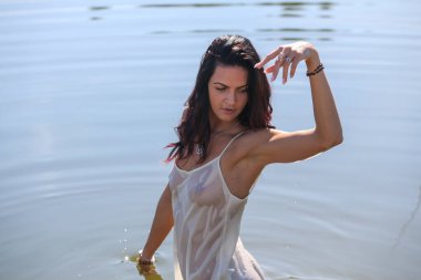 Portrait of a beautiful girl in a white wet shir