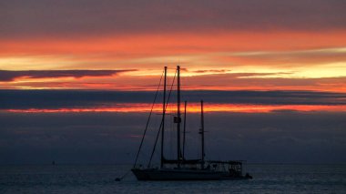 Dramatic tropical Florida sunset with yacht silhouette
