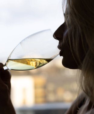 Beyaz şarap içen kadın, camlı siluet.