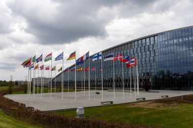 NATO üyesi ülkelerin ulusal bayrakları 20 Nisan 2023 'te Brüksel, Belçika' daki örgüt merkezinin önünde dalgalanıyor..