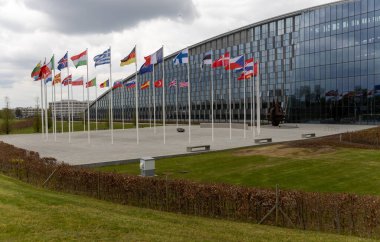 NATO üyesi ülkelerin ulusal bayrakları 20 Nisan 2023 'te Brüksel, Belçika' daki örgüt merkezinin önünde dalgalanıyor..