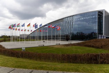 NATO üyesi ülkelerin ulusal bayrakları 20 Nisan 2023 'te Brüksel, Belçika' daki örgüt merkezinin önünde dalgalanıyor..