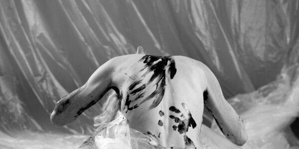 A young woman with a characteristic face is covered with colorful pain