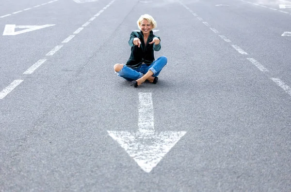 stock image Blonde adult woman posing with a good mood on a road sign