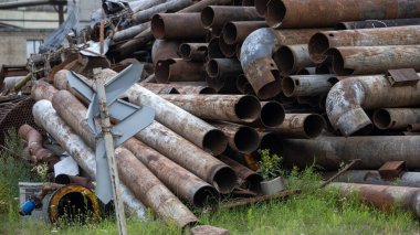 Gaz veya su rezervleri için demir borular biriktirilir ve bir yaz günü geri dönüşüm için hazırlanır. Arkaplan