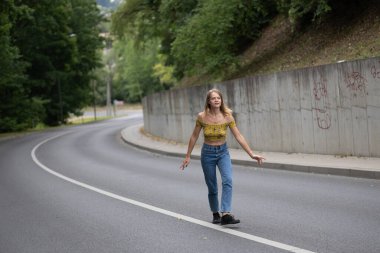 Genç ve güzel bir kız yolda bir viraja atlıyor.