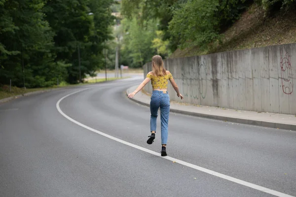 Una Joven Hermosa Chica Está Saltando Una Curva Carretera — Foto de Stock