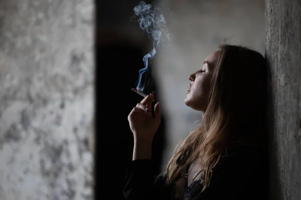 在模糊的背景下描绘一个吸烟的女孩 — 图库照片