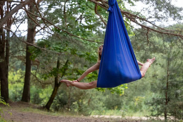 公園で空気シルクで反重力ヨガエクササイズをしている若い女性 — ストック写真