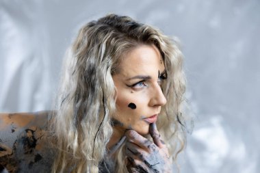 A young woman with a characteristic face is covered with colorful pain