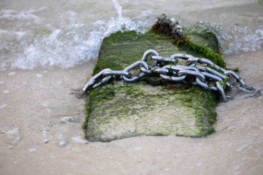 Deniz kıyısında beton üzerine çelik zincir