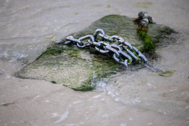 Deniz kıyısında beton üzerine çelik zincir
