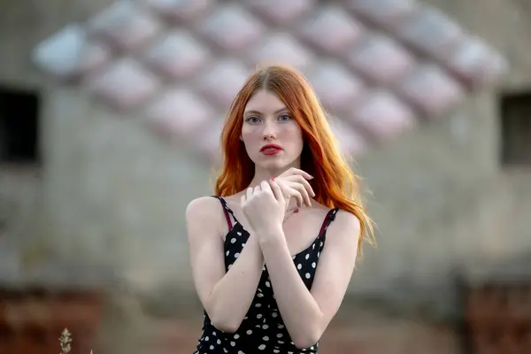 stock image Portrait of a redhead girl with long hair at the city.