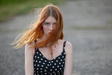 Yüzünde çiller olan kızıl saçlı bir kızın portresi.