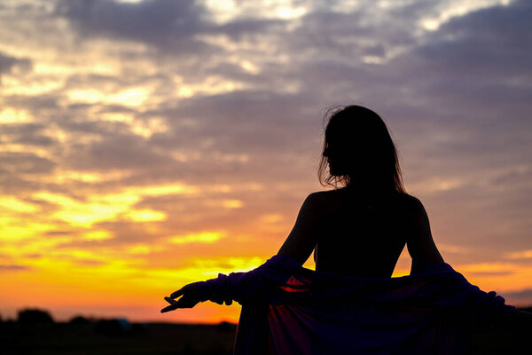 Женский силуэт на фоне вечернего неба, с потрясающим осенним небом