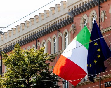 Italian flag waving above city buildings, red, white, green clipart