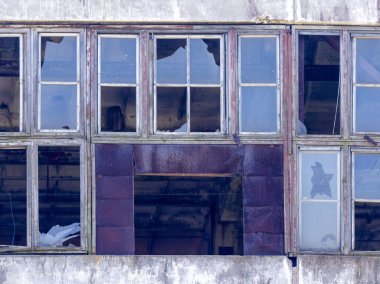 Abandoned industrial building, shattered windows, forgotten by people, an industrial reli clipart