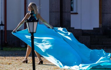 Sonbahar Moda Fotoğrafı: Güzel Bir Kadın ve Rüzgâr Süpüren Mavi Elbise