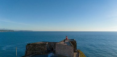 Kırmızı deniz feneri lamba Oda Nazare, Portekiz mavi gökyüzü ve denizin arka plan üzerinde