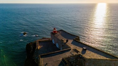 Kırmızı deniz feneri lamba Oda Nazare, Portekiz mavi gökyüzü ve denizin arka plan üzerinde